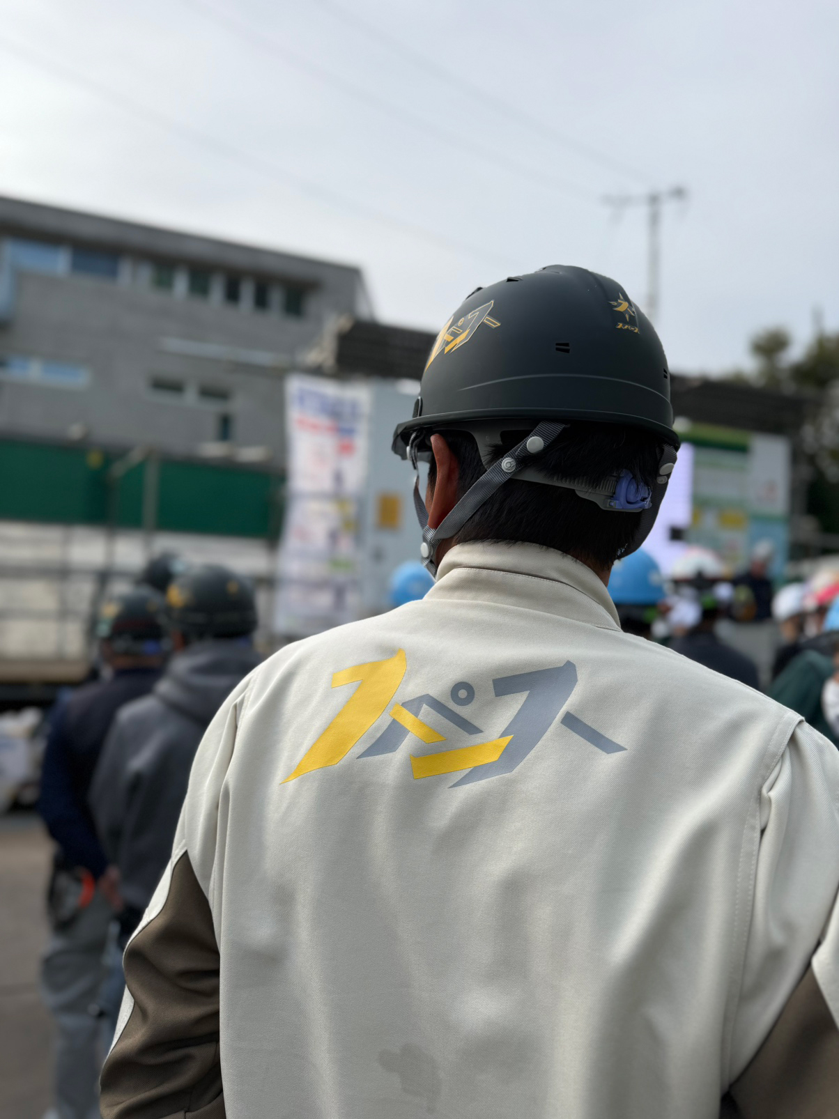 会社のユニフォームを着た1人の社員の背中